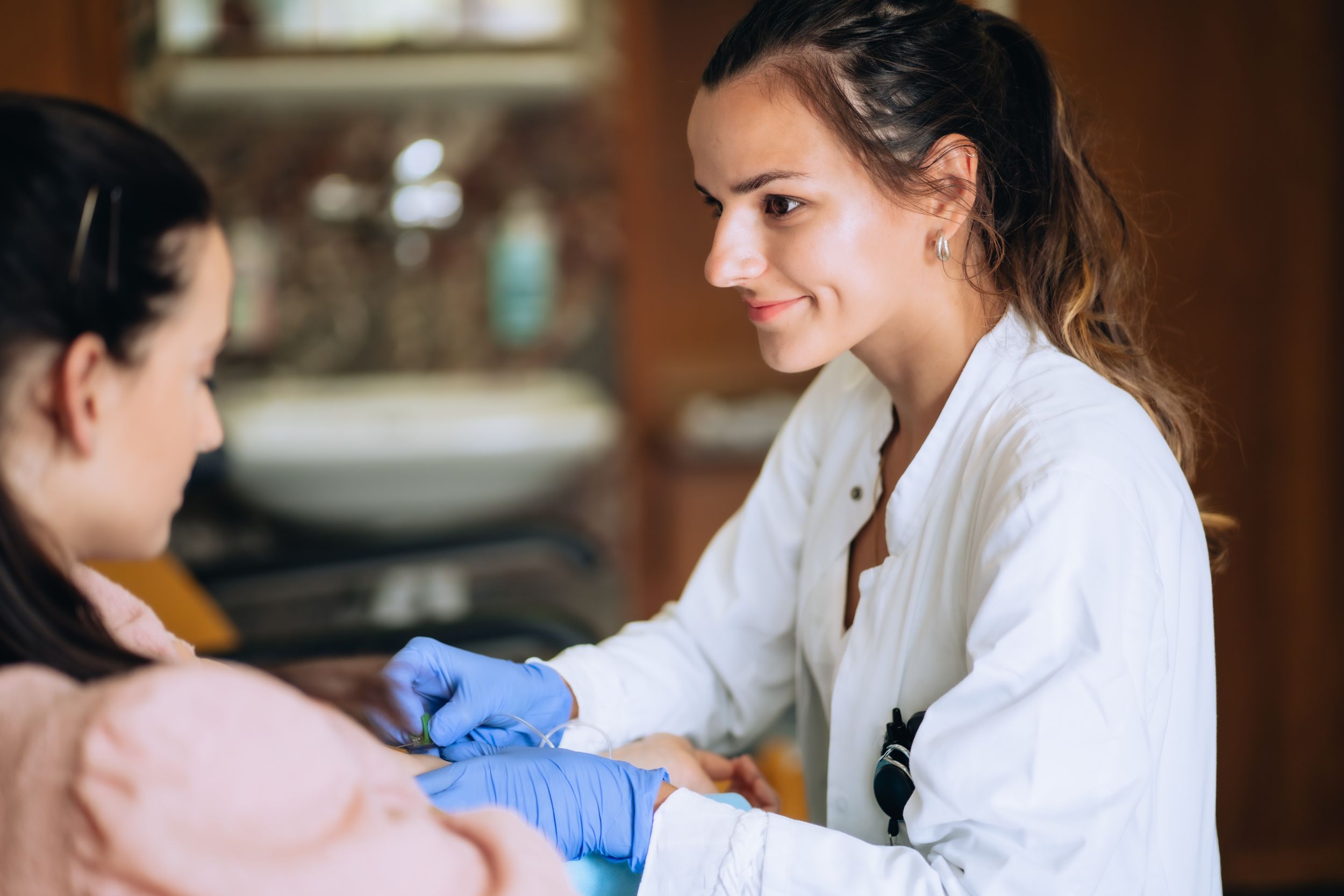 Ärztin mit blauen Handschuhe behandelt eine Patientin