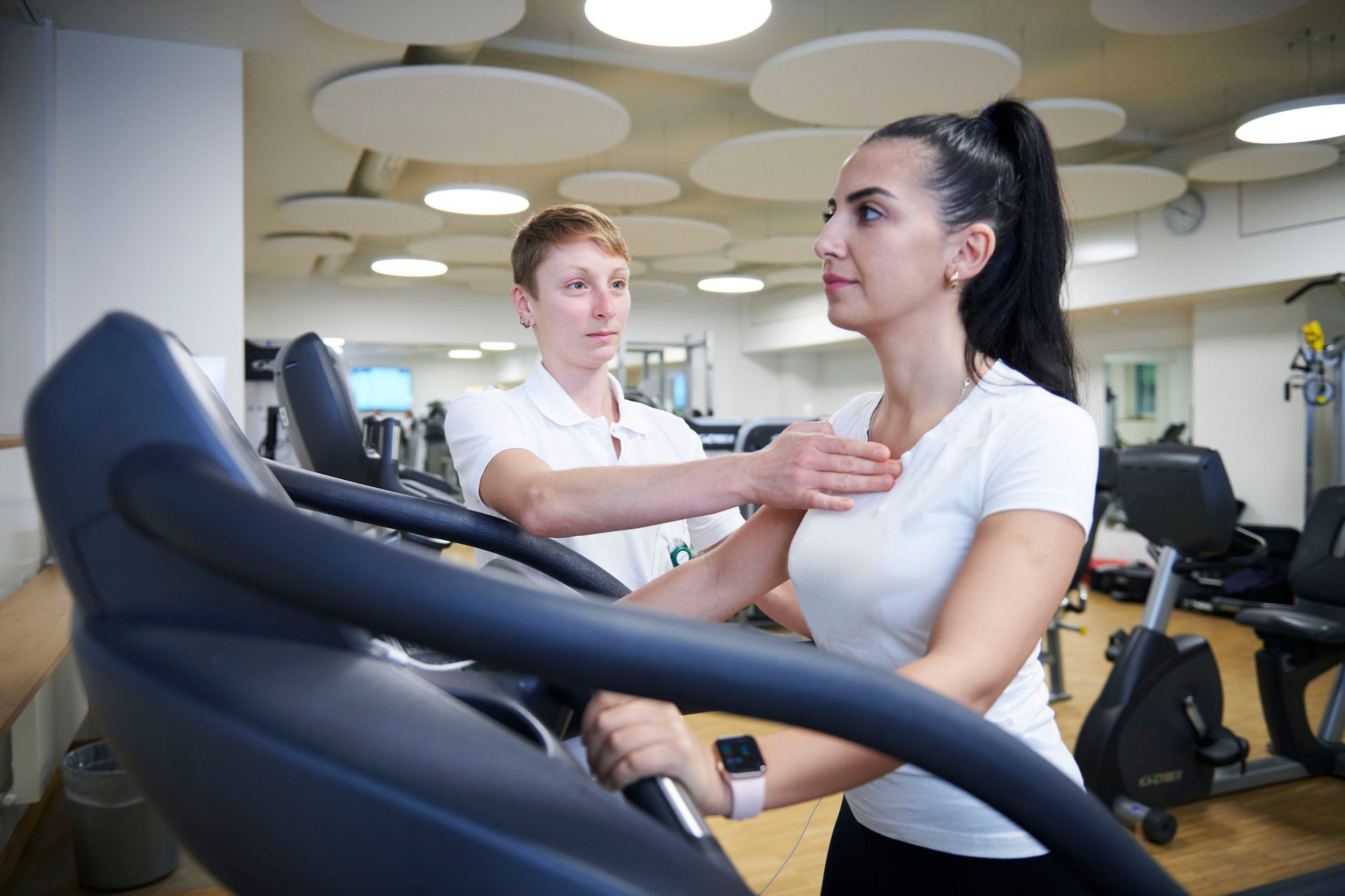 Eine Patientin auf dem Laufband unter Anleitung der Therapeutin