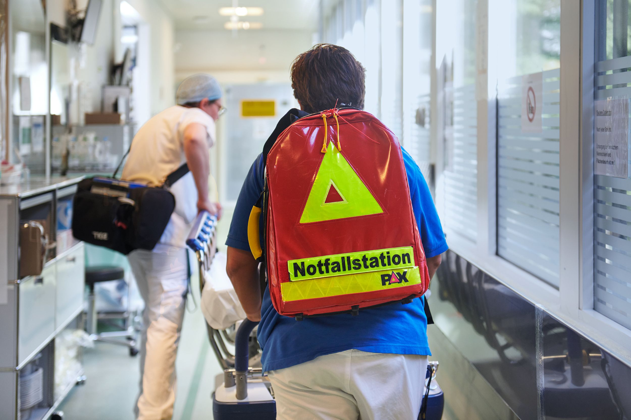 Patient wird auf dem Notfall im Bett durch einen Gang transportiert