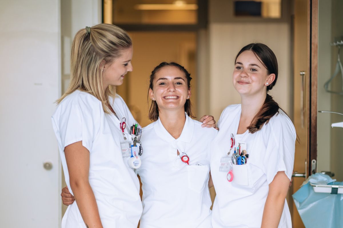 Drei junge Frauen in Berufkleidung lachen