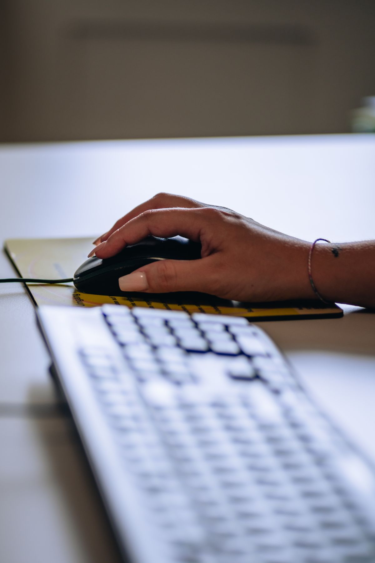 Hand auf Maus neben Tastatur